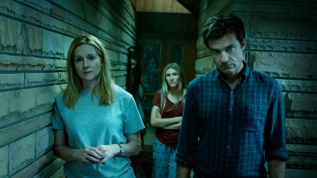 Jason Bateman, Laura Linney, dan Sofia Hublitz berdiri dalam sebuah ruangan memerankan karakter di Ozark.